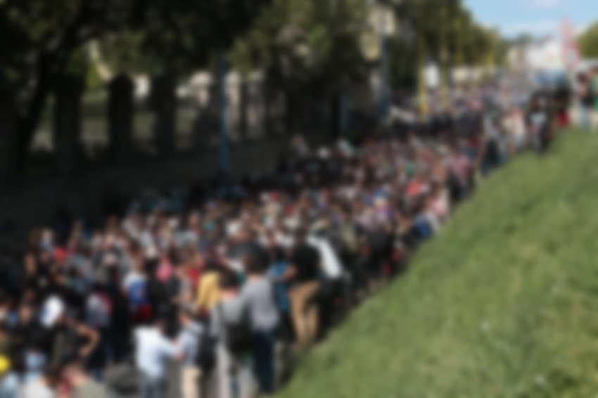 Hundreds of migrants walk after leaving the transit zone of the Budapest main train station, on September 4, 2015 intenting on walking to the Austrian border. They were part of an estimated 2,000 migrants stuck in makeshift refugee camps at Keleti station, after railway authorities had blocked them from boarding trains to Austria and Germany. AFP PHOTO / FERENC ISZA